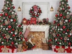 three decorated christmas trees in front of a fireplace with presents on the mantle and wreaths around them