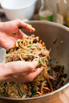 two hands grabbing food out of a bowl