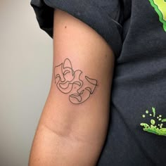 a person with a tattoo on their arm that has an image of the face of mickey mouse