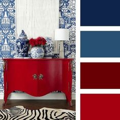 a red cabinet with blue and white wallpaper in the background, along with a zebra print rug