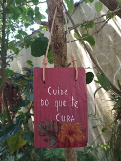 a sign hanging from the side of a tree with writing on it that says, guide do que te cura