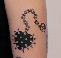 a person with a tattoo on their arm has a chain attached to the wrist and two skulls