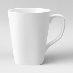 a white coffee cup sitting on top of a table