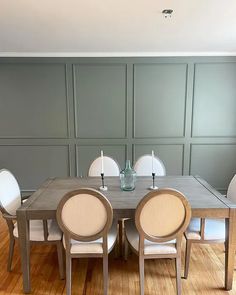 a dining room table with white chairs around it