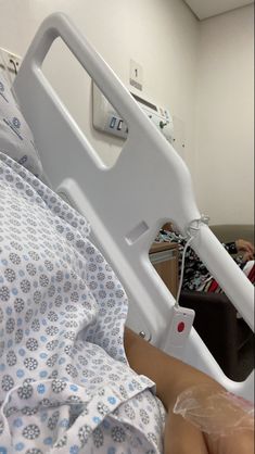 a person laying in a hospital bed with an iv device attached to the back of it