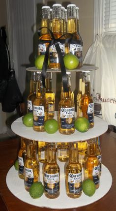 there is a three tiered display with bottles and limes on it