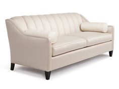 a white leather couch sitting on top of a hard wood floor