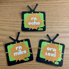 three square shaped magnets with the words ra and echo on them sitting on a wooden surface