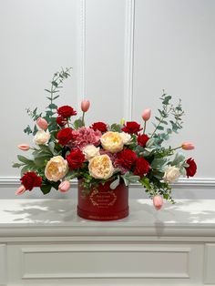 a bouquet of red and white flowers sitting on top of a table