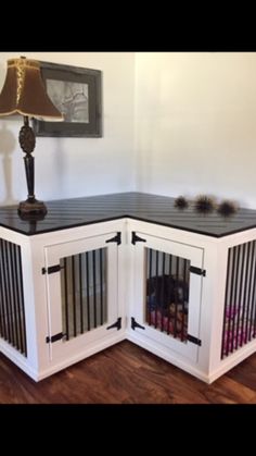 a dog kennel in the corner of a room with a lamp on top of it