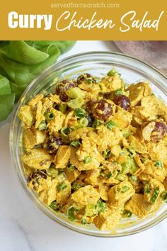 a glass bowl filled with chicken salad on top of a table