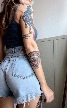 a woman with tattoos on her arm and leg