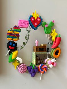 a mirror that has various items on it in the shape of a circle, including candy and lollipops