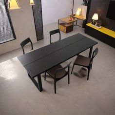 a dining table and chairs in a room with white tile flooring, black walls and yellow accents