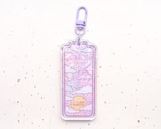 a pink luggage tag hanging on a white wall