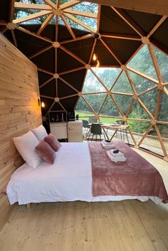 a bed sitting inside of a bedroom next to a wooden wall