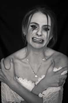 a woman with makeup on her face and hands around her chest, posing for the camera