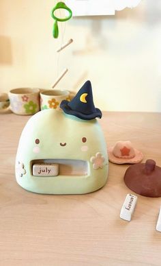 an alarm clock with a witches hat on top and other items around it sitting on a table