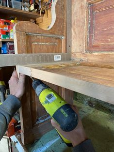 a man is using a drill to attach the shelf