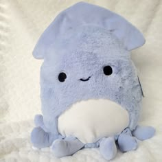 a blue stuffed animal sitting on top of a bed