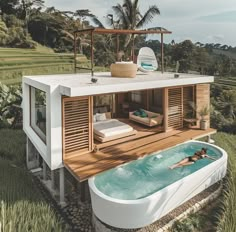 a woman swimming in an outdoor jacuzzi tub next to a deck with lounge chairs