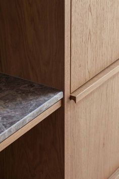 a wooden cabinet with marble top and drawers