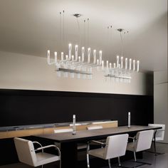 a dining room table with chairs and chandelier hanging from it's ceiling