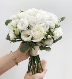 a person holding a bouquet of white flowers