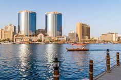 a boat is on the water in front of some tall buildings