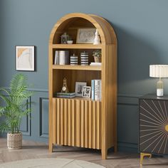 a wooden book shelf with books on it next to a lamp and a potted plant