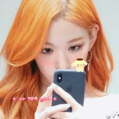 a girl with red hair is looking at her cell phone