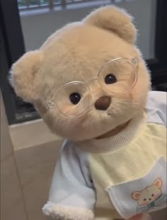 a teddy bear wearing glasses and a sweater