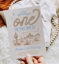 a person holding up a card with the words wild one in the west on it