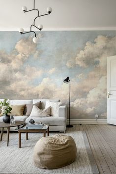 a living room filled with furniture and a large painting on the wall above it's couch