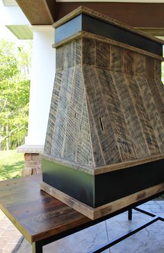 a wooden stove sitting on top of a picnic table