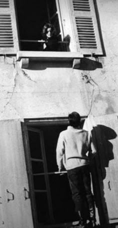 black and white photograph of man looking out window