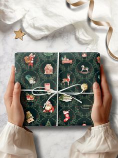 a woman's hands holding a christmas wrapping paper