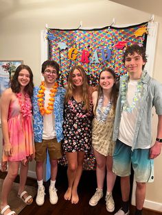 a group of young people standing next to each other in front of a bulletin board