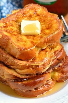 a stack of french toast with butter on top and syrup in the backgroud