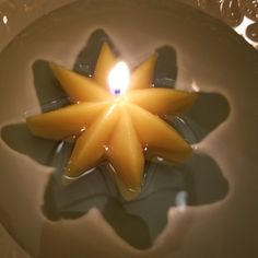 a candle that is floating in some water