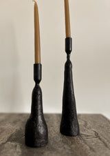 two black candlesticks sitting on top of a table