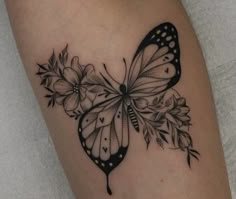 a black and white butterfly with flowers on it's back side arm tattoo design