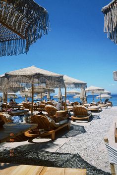 many umbrellas and lounge chairs on the beach