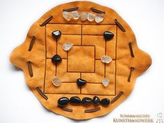 a game board with stones and pins arranged in the shape of a circle on a white surface