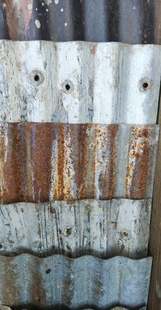 an old wooden fence with rusted paint on it