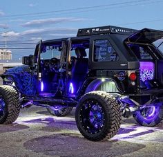 an off road vehicle with purple lights on it's tires is parked in a parking lot