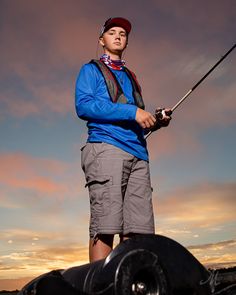 a man standing on top of a boat holding a fishing pole