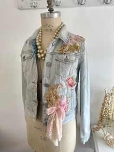 a mannequin wearing a jean jacket with flowers and pearls