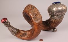 a silver and wood pipe with a red ball on top