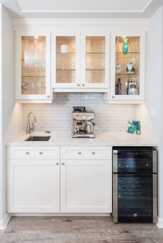 a kitchen with white cabinets and an oven in the center, along with a black dishwasher